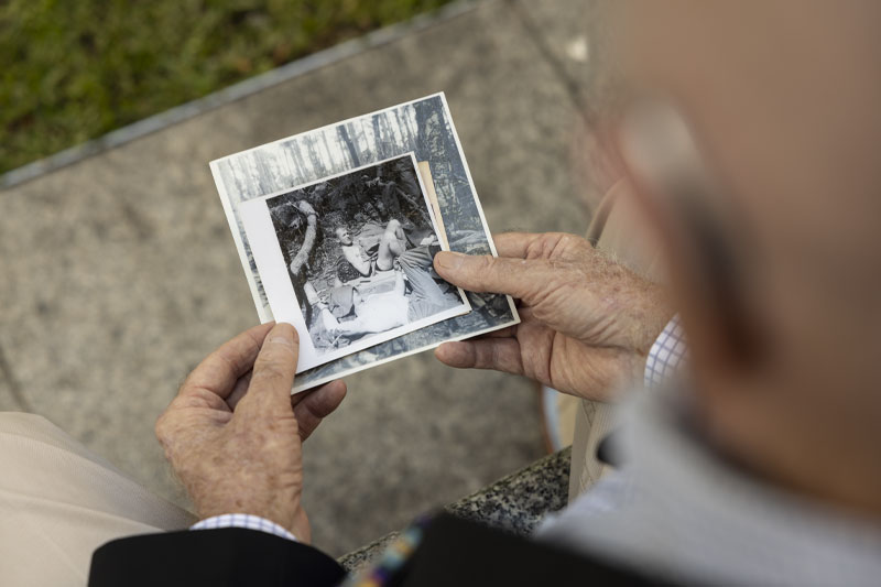 Kel Ryan holding an image of himself taken during the Vietnam War. 