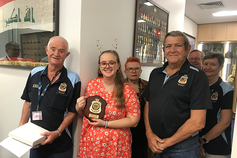 Kedron-Wavell RSL Sub Branch President Ken Roma, front right, presents a medallion to student Sophie Morley in recognition of her participation in the liaison program. Also pictured, from left, Kedron-Wavell RSL Sub Branch Senior Vice President Greg Peake OAM, Sue Stern, Glen Dyer and Trish Whitby. 