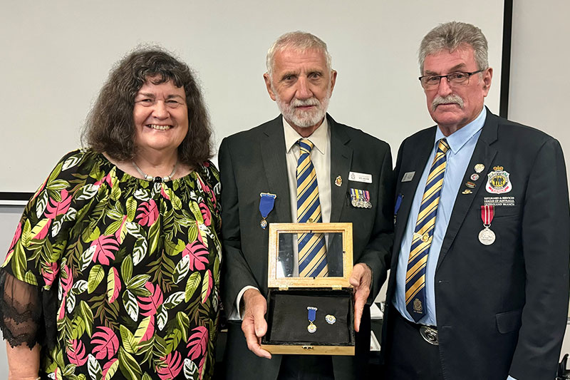 Noel (center) receives the RSL Meritorious Service Medal