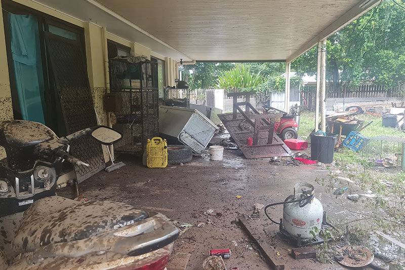 House after flooding, furniture scattered and covered in mud. 