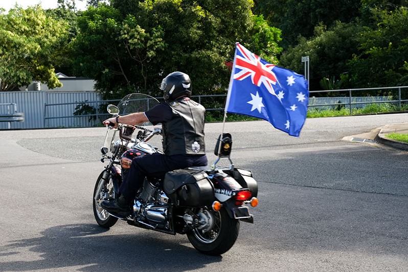 Ken Cook riding his motorbike with the Australia flag