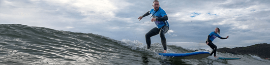 Man in blue rash shirt learns to surf